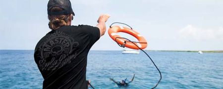 Instructor throwing a life ring to save a diver in a Rescue class scenario.